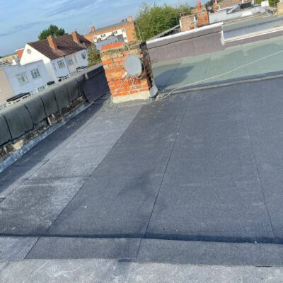 Flat felt roof with chimney and parapet flashing